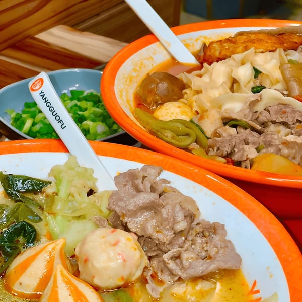 Two bowls of YGF Malatang with various ingredients, including meat, vegetables, and noodles.